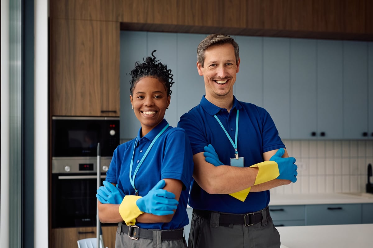 Happy diverse professional cleaning team standing with arms crossed